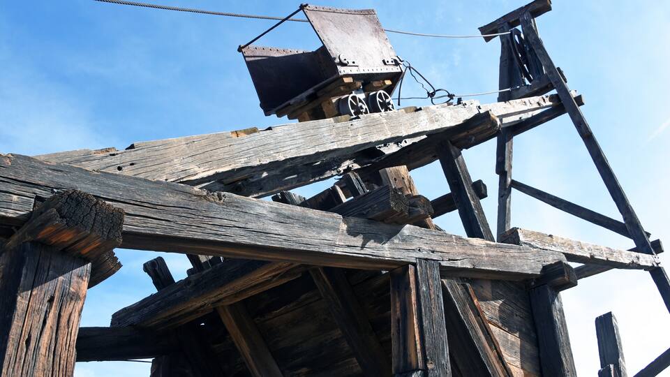 Looking up at an old mining cart on a wooden headframe in Vulture City, Arizona