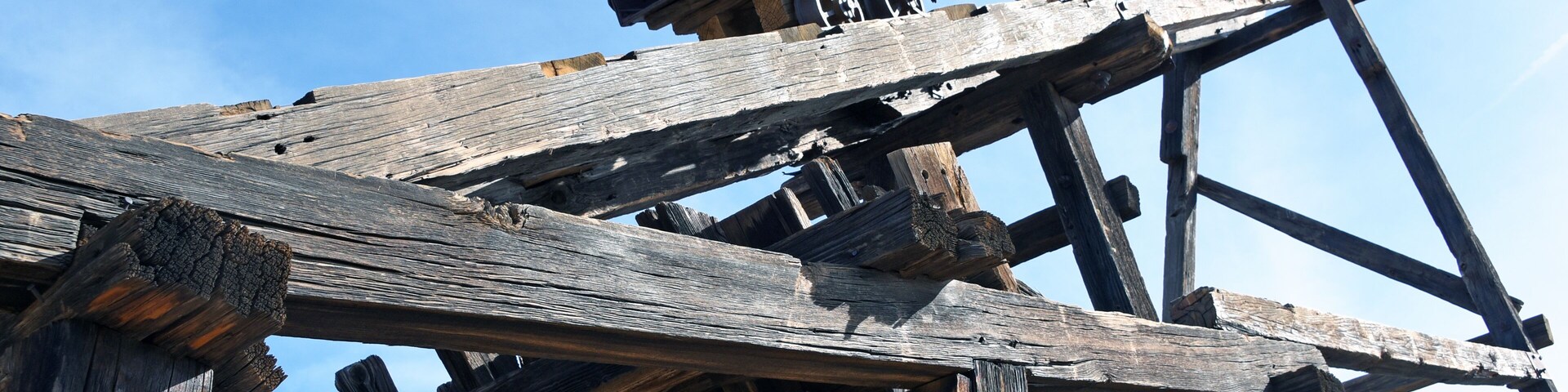 Looking up at an old mining cart on a wooden headframe in Vulture City, Arizona