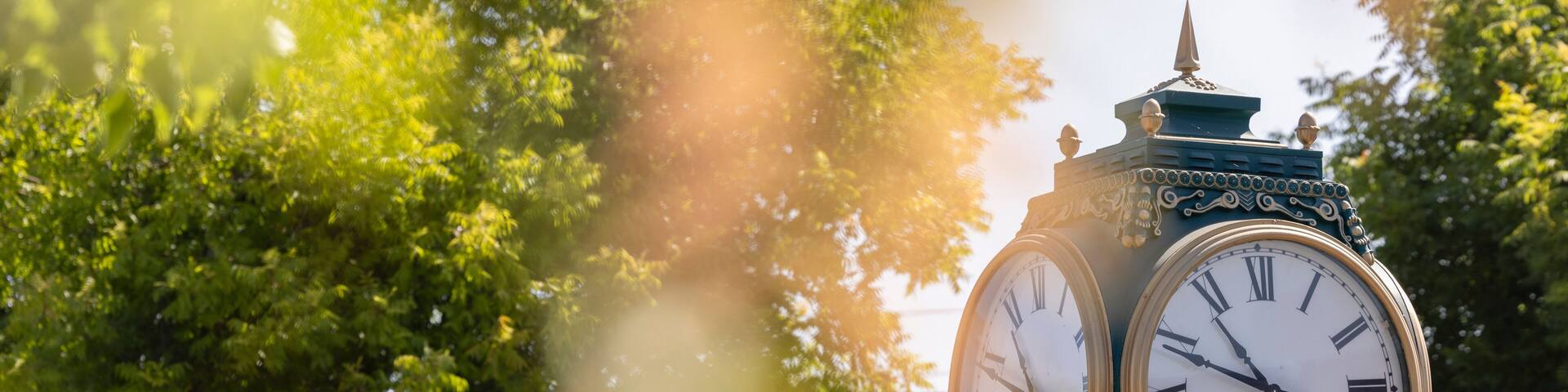 Los Altos, California, USA - August 30, 2024: Morning traffic passes the historic wrought iron clock in the historic downtown district.