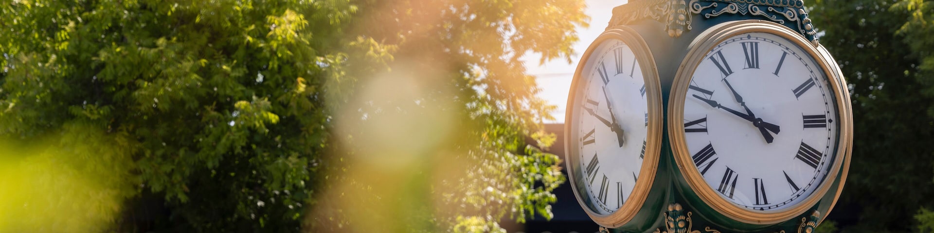 Los Altos, California, USA - August 30, 2024: Morning traffic passes the historic wrought iron clock in the historic downtown district.