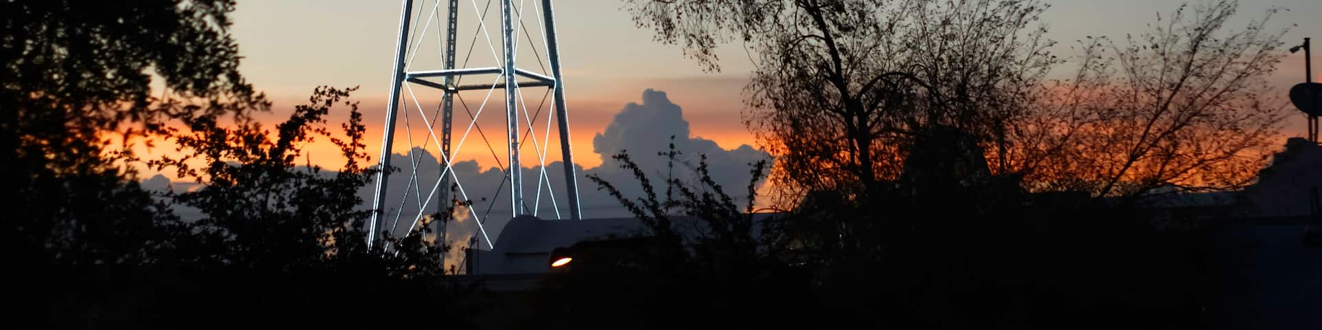 A water tower with the name 'Gilbert' against a sunset sky.