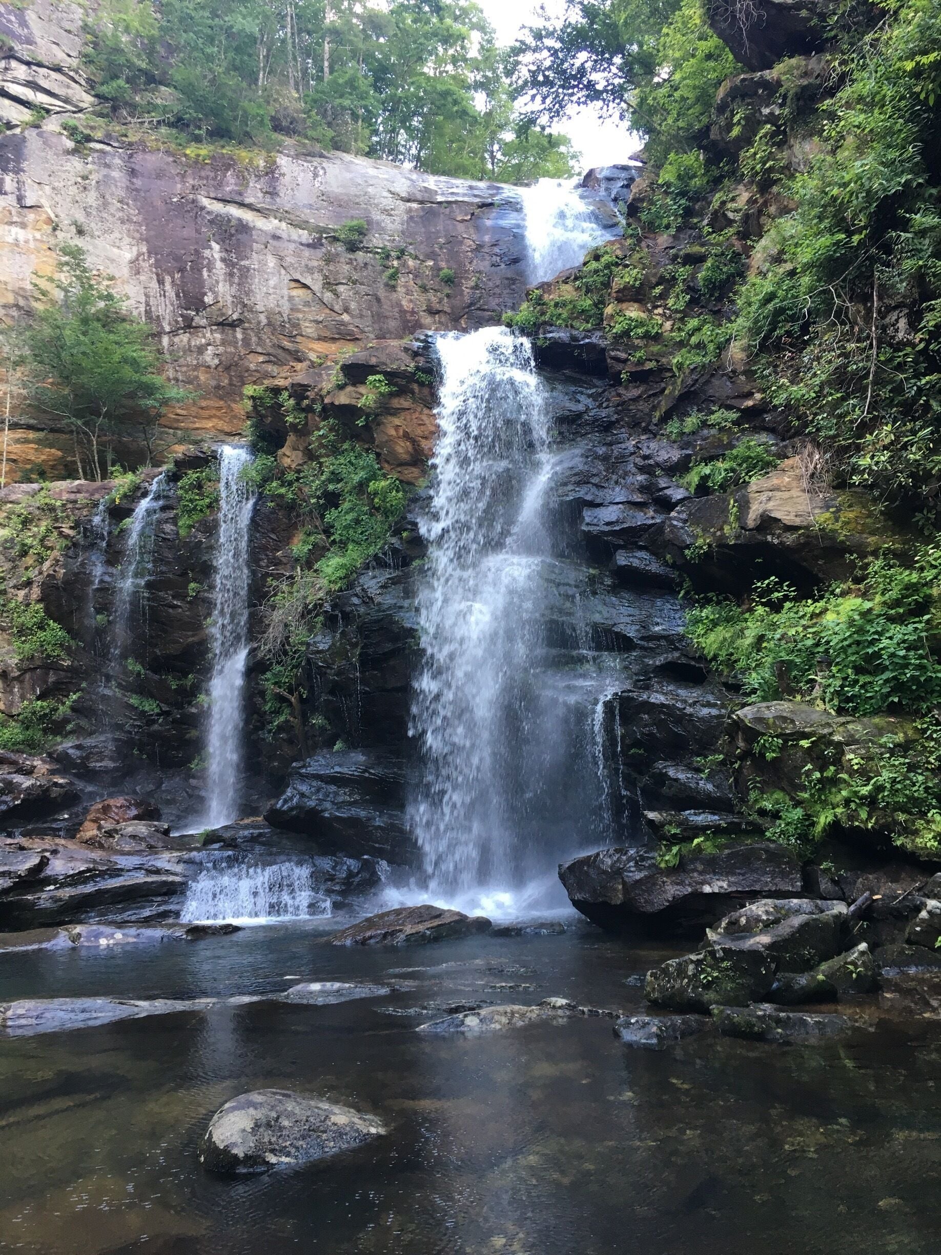 A waterfall cascading over rocky terrain surrounded by lush greenery.