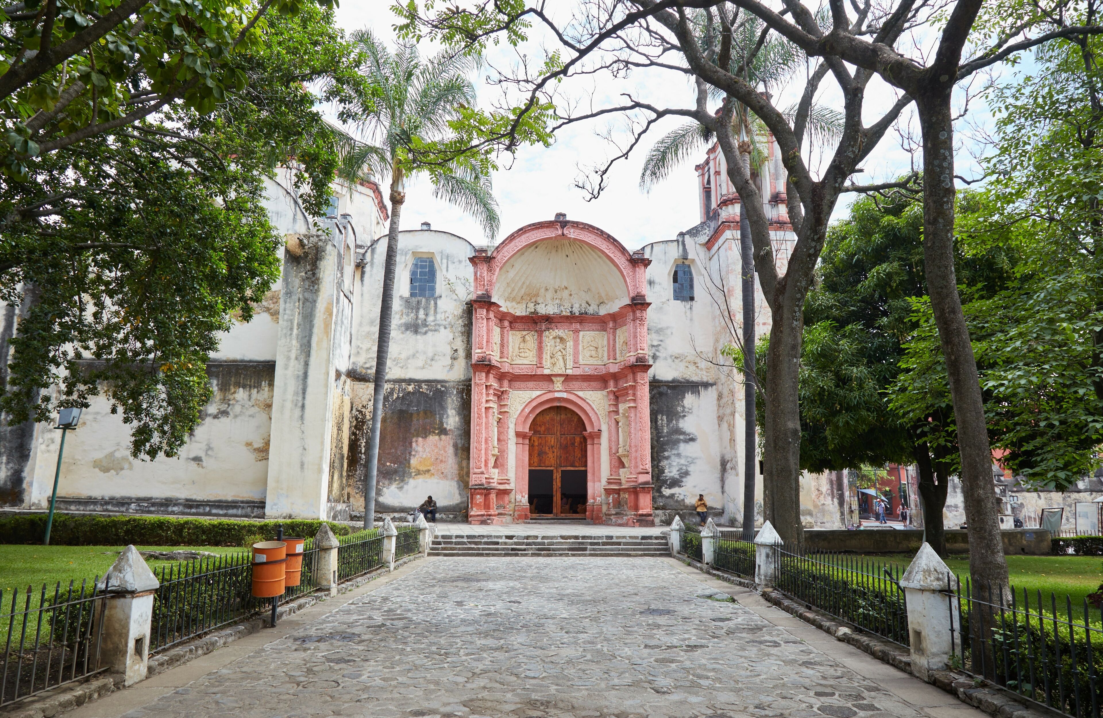 A historic building with a pink archway and steps leading to the entrance.