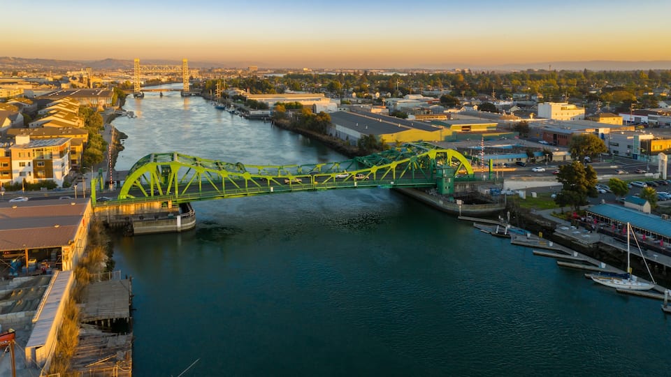 Aerial view of the Park Street Bridge, Alameda, California, USA, with boats docked in the foreground. The bridge connects the Alameda waterfront.