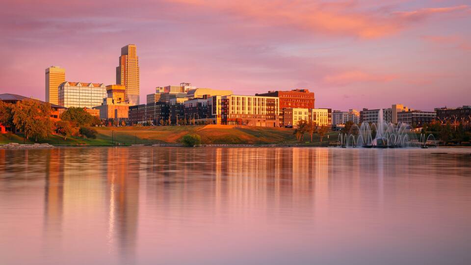 Omaha, Nebraska, USA. Cityscape image of downtown Omaha, Nebraska with reflection of the skyline at beautiful autumn sunrise.