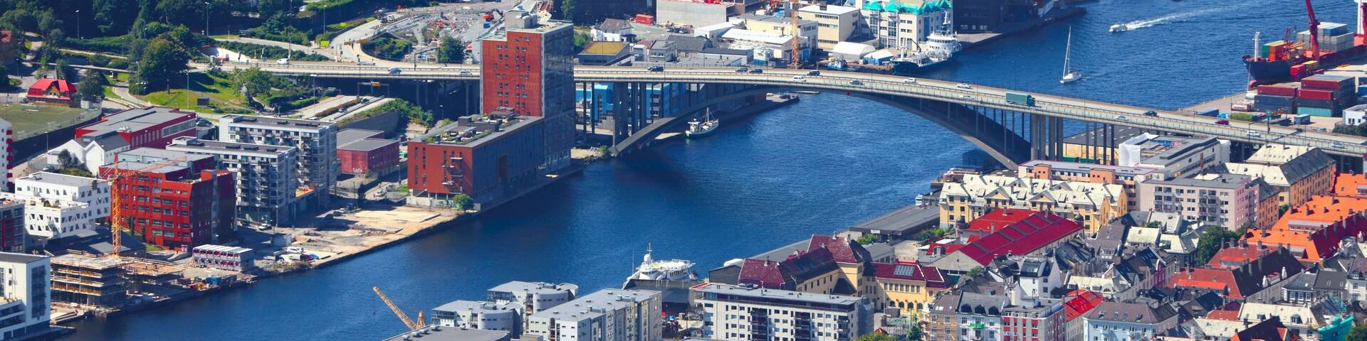 A coastal city with a prominent bridge, dense residential areas, and a marina.