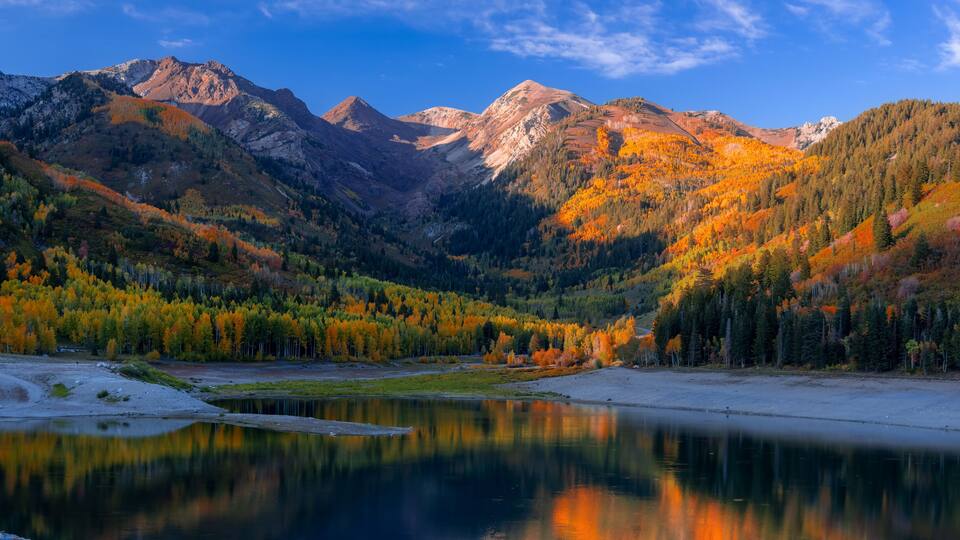 Scenic Silver lake reservoir landscape in Utah, Wasatch mountain range, under evening sunlight.