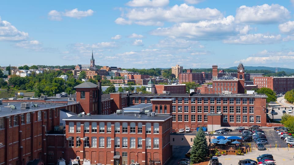 Manchester historic city skyline including Amoskeag Mill buildings and West Side Sainte Marie Parish church in Manchester, New Hampshire NH, USA.