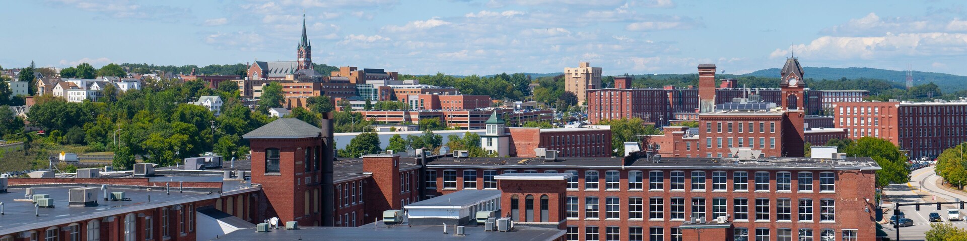 Manchester historic city skyline including Amoskeag Mill buildings and West Side Sainte Marie Parish church in Manchester, New Hampshire NH, USA.