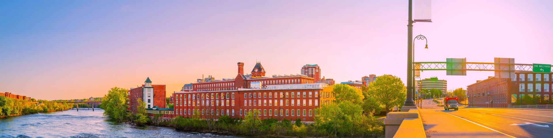 Manchester city skyline, Granite Street Bridge, and the Merrimack River at sunrise in New Hampshire, USA