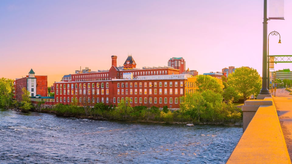 Manchester city skyline, Granite Street Bridge, and the Merrimack River at sunrise in New Hampshire, USA
