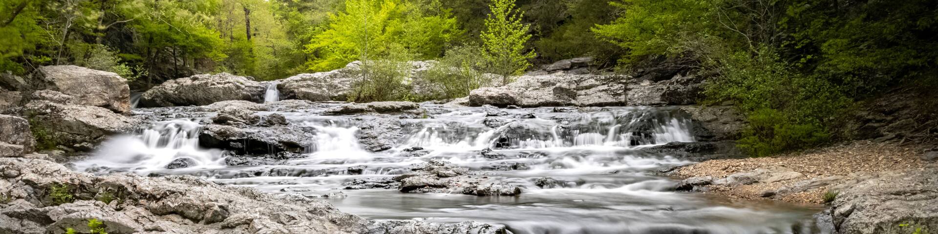 A waterfall cascading over rocks in a forested area.