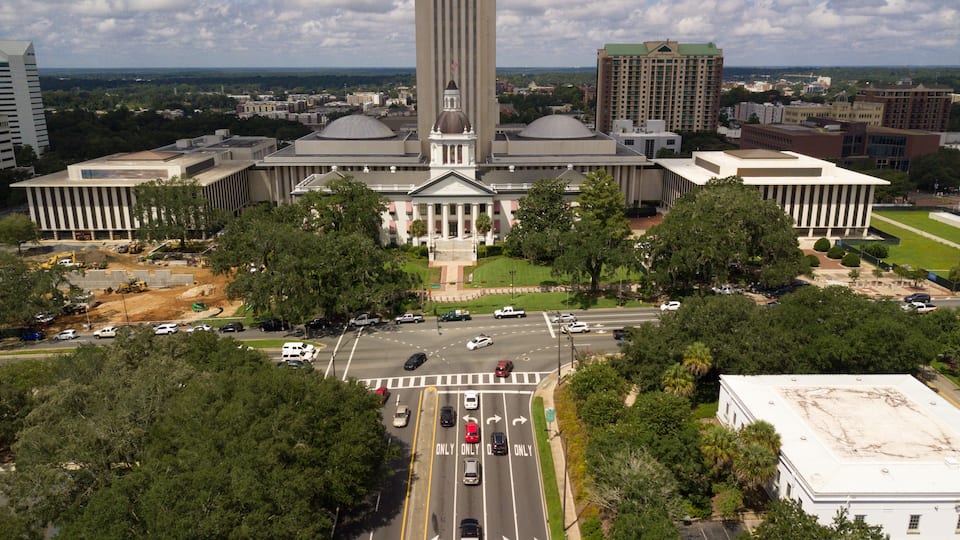 Flags Blow Atop Traffic Below The Capital Dome in Tallahassee Florida