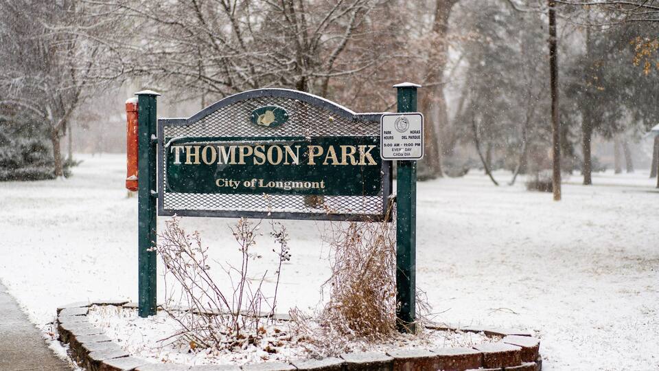 Thomson Park sign in Longmont, Colorado, covered in first winter snow