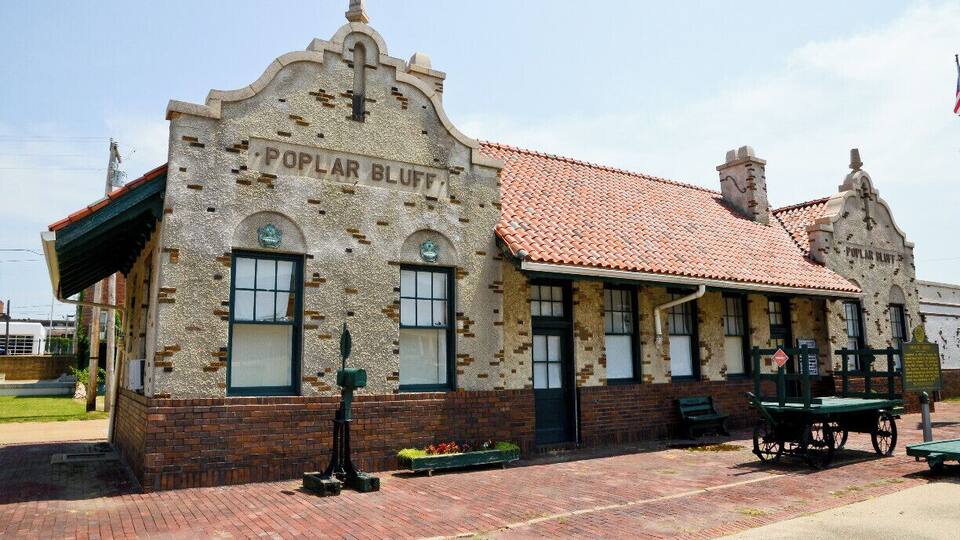 A historic building named 'Poplar Bluff' with a red-tiled roof and brick facade.