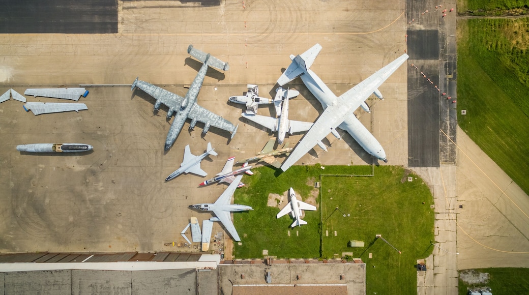 An aerial view of an airport with multiple aircraft parked on the tarmac, including large commercial jets and smaller planes.