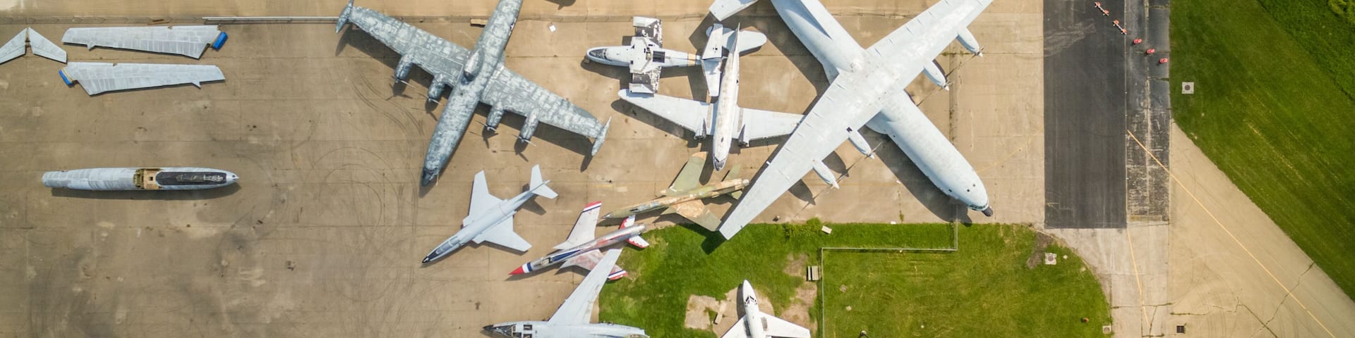 An aerial view of an airport with multiple aircraft parked on the tarmac, including large commercial jets and smaller planes.