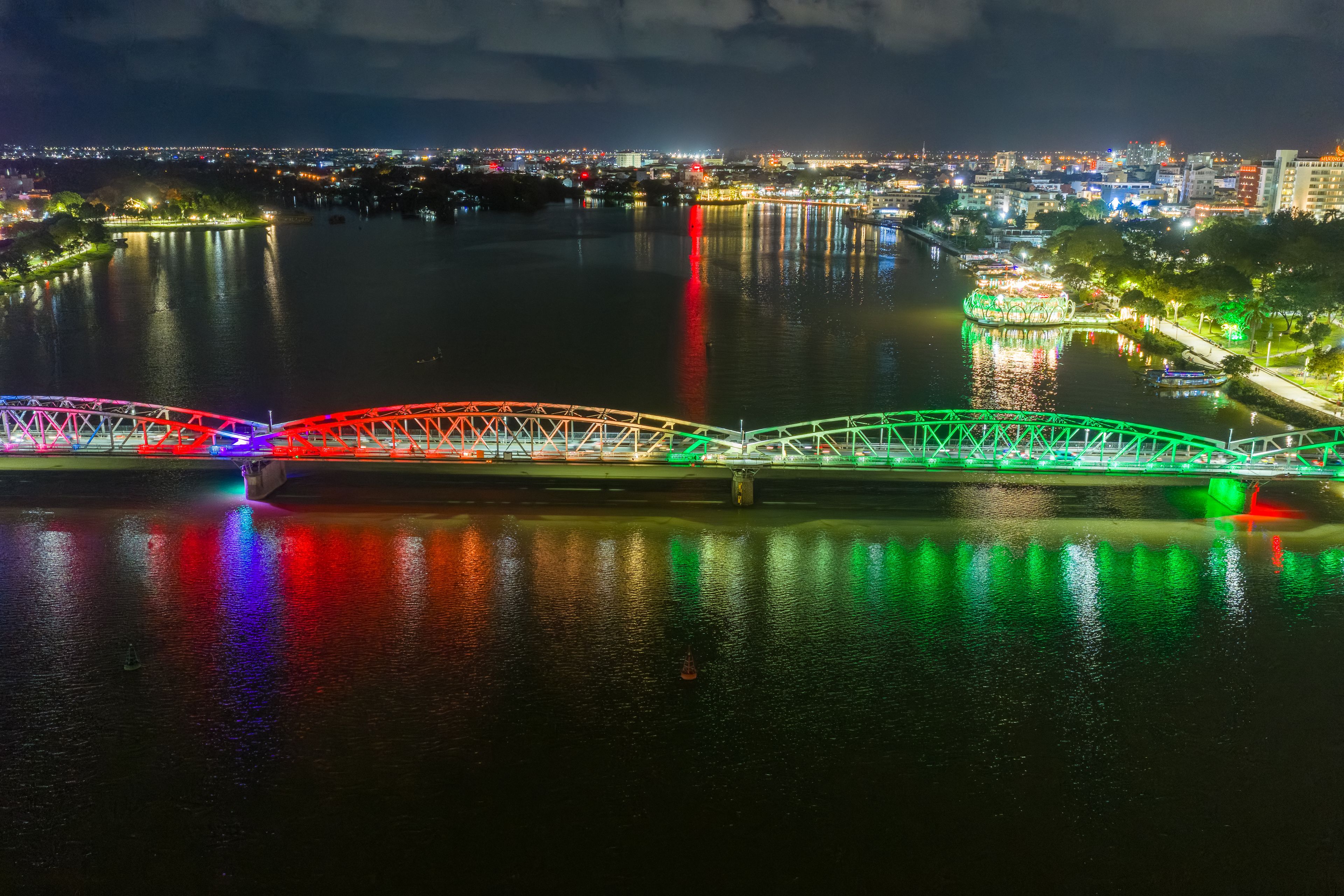 Panoramic view of Truong Tien Bridge in Hue City at night. Bridge illuminated all over with blurry reflection on. Travel and landscape concept