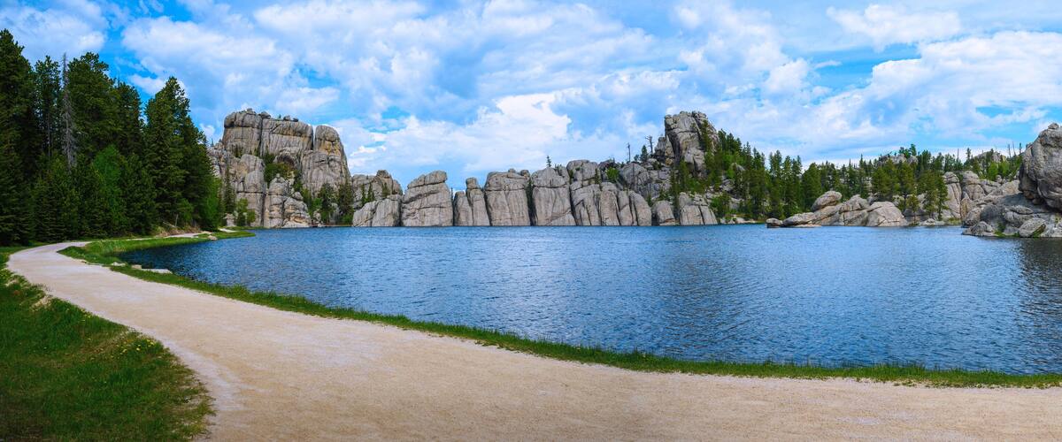 A lake surrounded by rocky cliffs and dense forest.