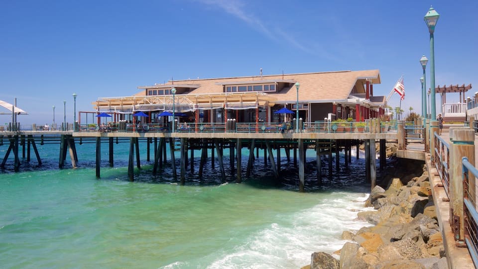 A pier extending into turquoise waters with a restaurant and outdoor seating.
