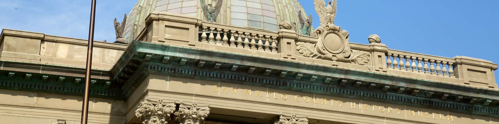 The San Mateo County History Museum with a large dome, an American flag, and ornate architectural details.