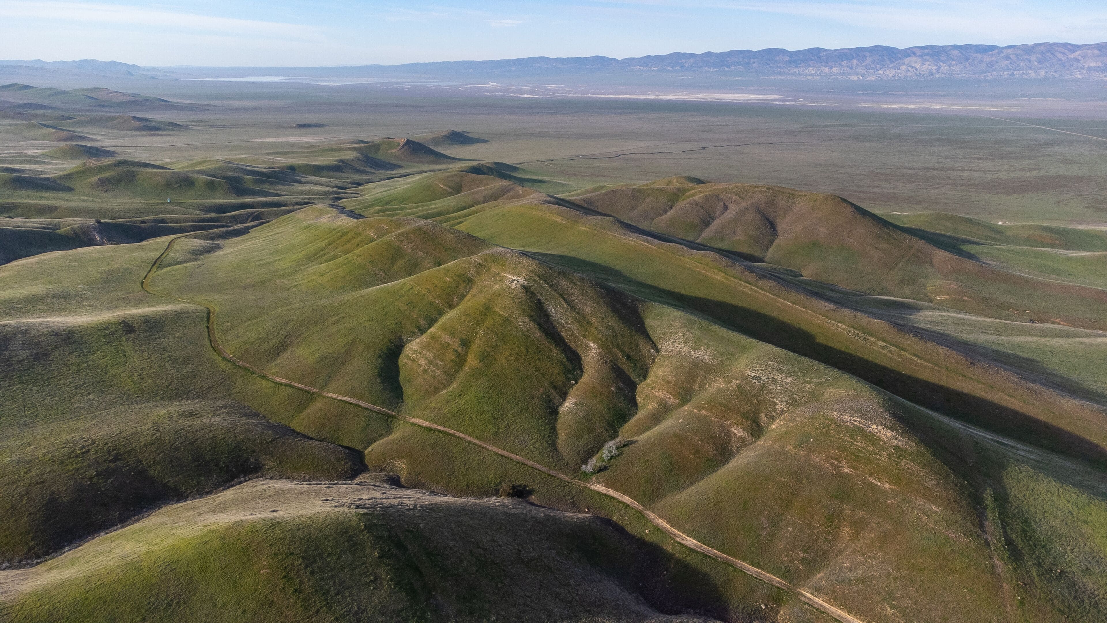 Colinas ondulantes con un camino de tierra que atraviesa el paisaje.