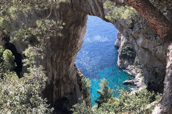 Une arche naturelle formée par la roche, d’où l’on peut admirer la mer en contrebas.