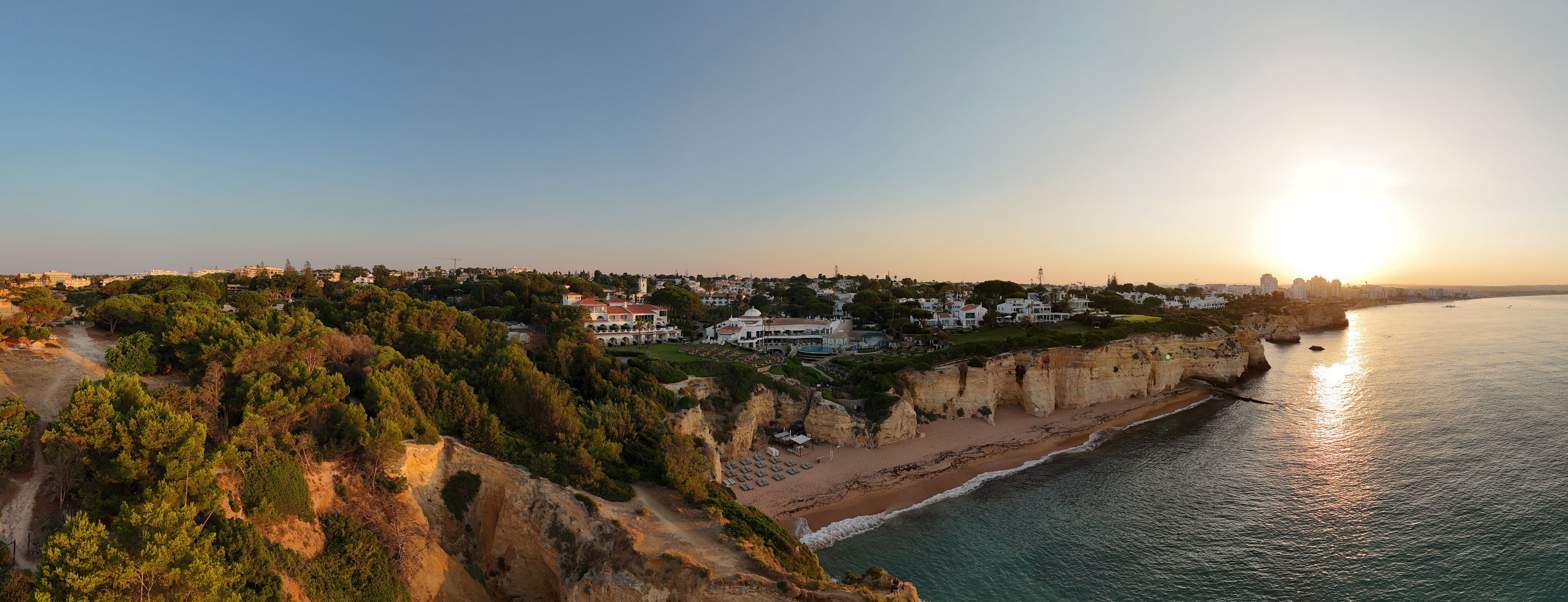 A coastal town with a cliffside, beach, and ocean.