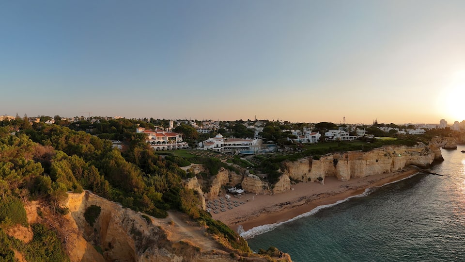 A coastal town with a cliffside, beach, and ocean.