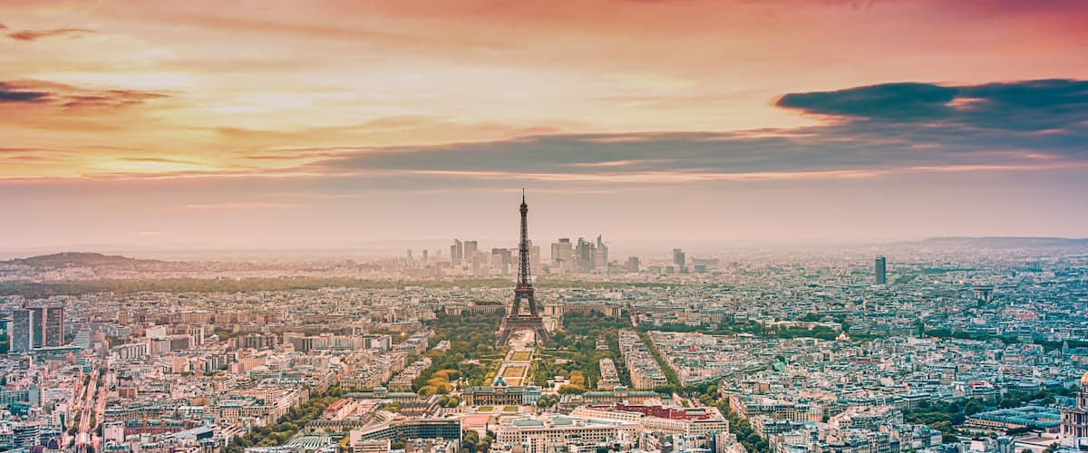 A cityscape with the Eiffel Tower, dense urban buildings, and a clear sky.
