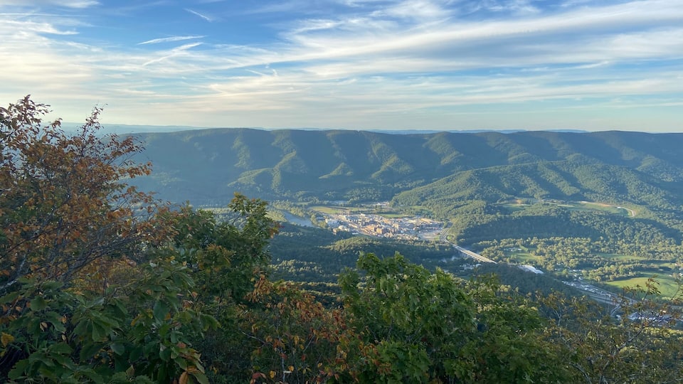 A valley with a river, a bridge, and a town surrounded by hills.