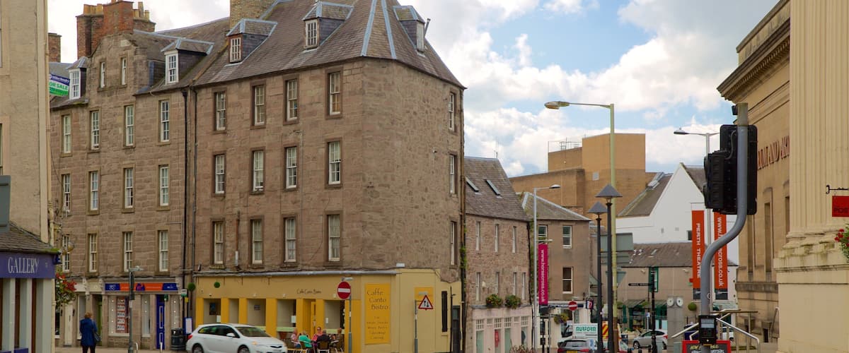A street with a historic building, a cafe, and a traffic light.