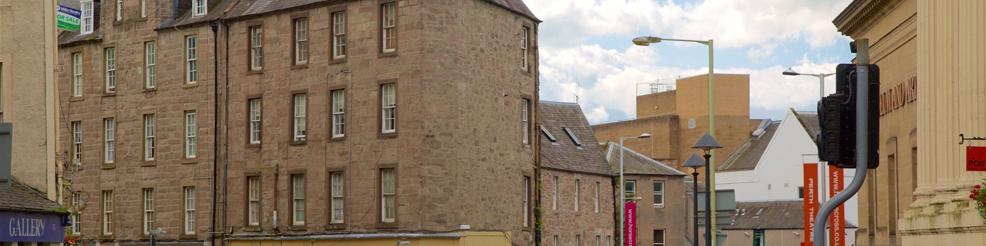 A street with a historic building, a cafe, and a traffic light.