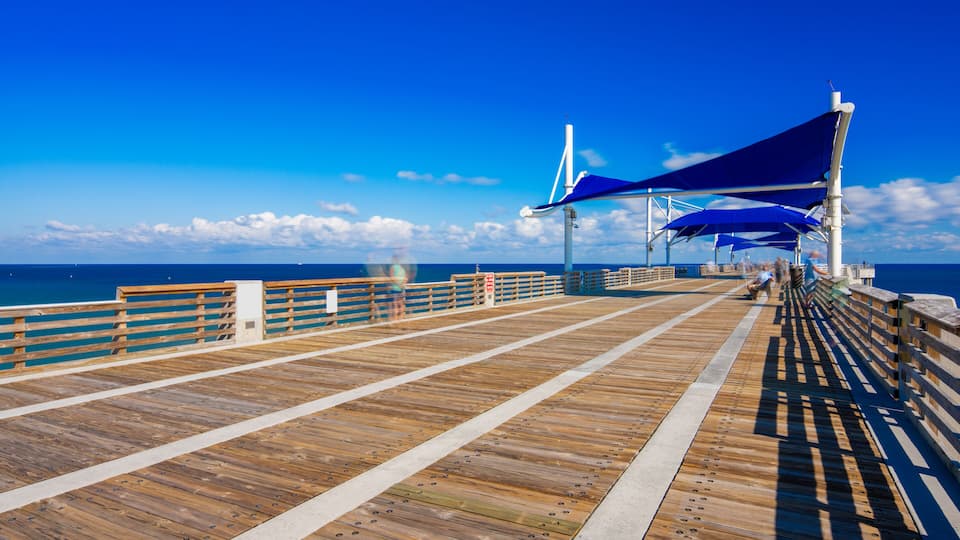 Pompano Beach Fishing Pier over the Atlantic Ocean. Long exposure to blur clouds and people