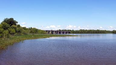 Panorama James River landscape with spring flora, blue sky and bridge. Hopewell, Virginia.