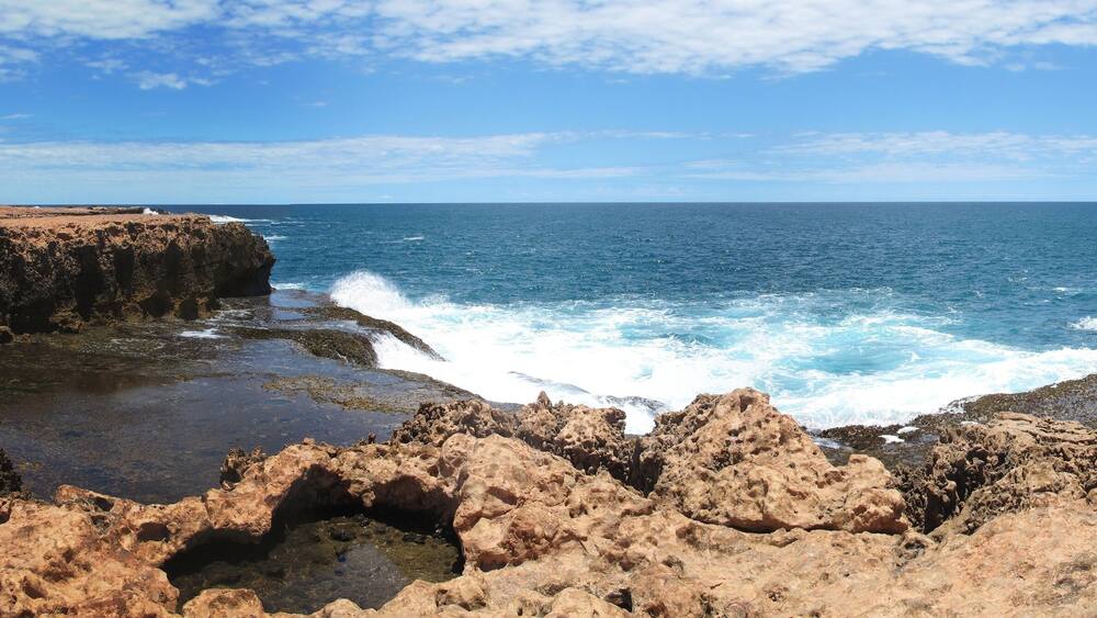 A rocky coastline with waves crashing against the shore.
