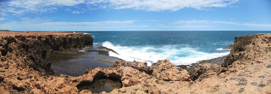 A rocky coastline with waves crashing against the shore.