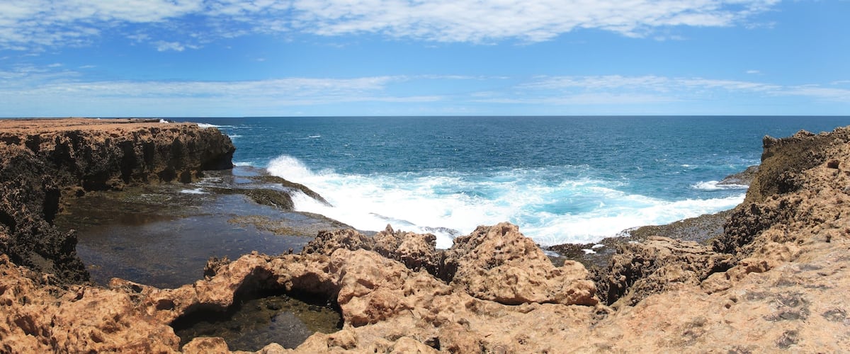 A rocky coastline with waves crashing against the shore.