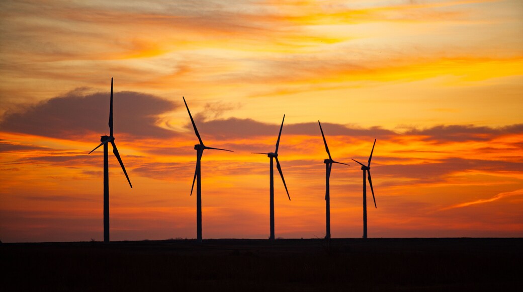 Wind turbines silhouetted against a sunset sky.
