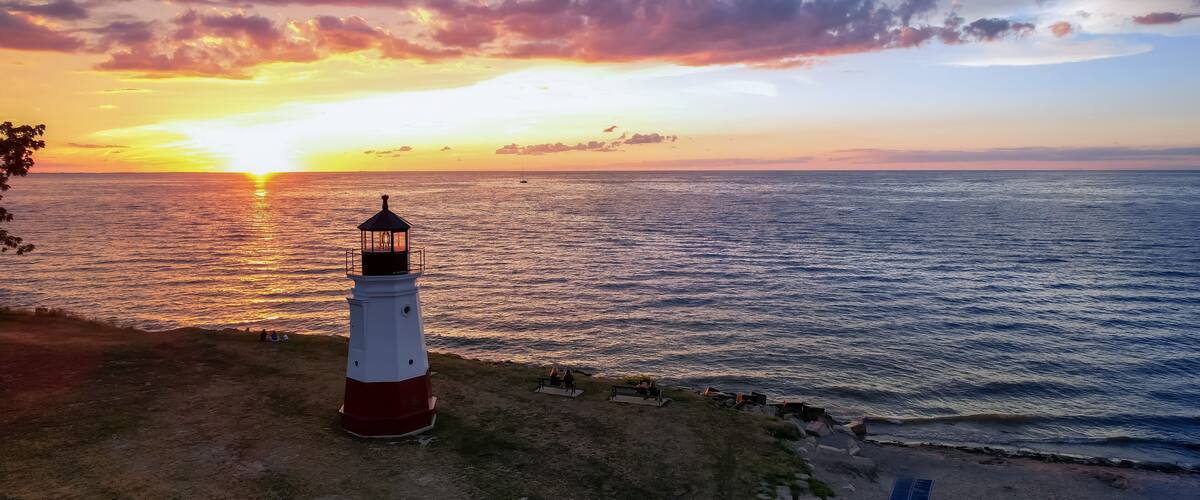 Historic Vermilion Lighthouse at harbor view state park in Vermilion city Ohio under evening light.