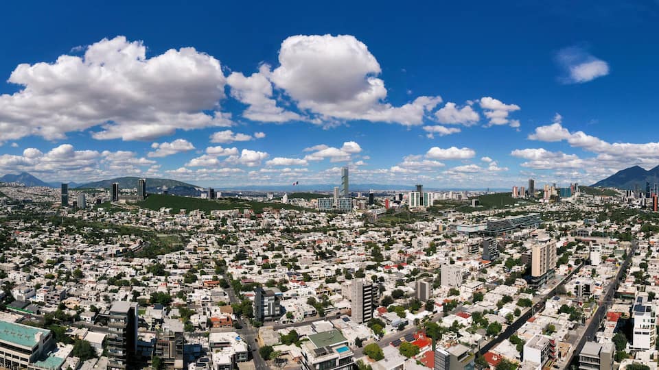 A panoramic view of a city with a prominent mountain range in the background.