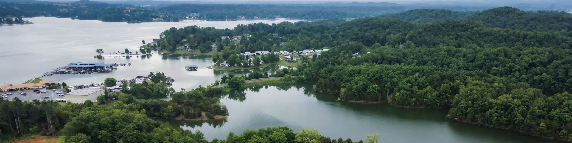 Aerial view of serene lake surrounded by forested hills and cloudy sky, dandridge, tennessee, united states.