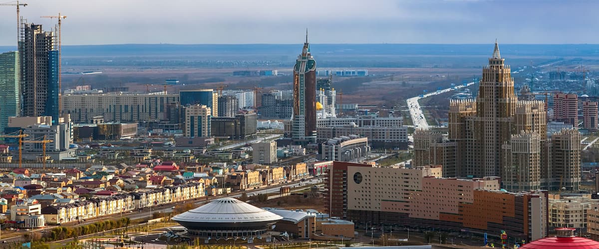 A cityscape with prominent skyscrapers, including a tall building with a pointed top and another with a golden dome.