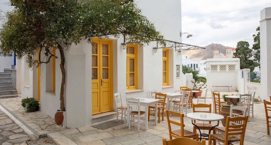 Greece. Tinos island Cyclades. Outdoors traditional cafe with yellow windows at Pyrgos village