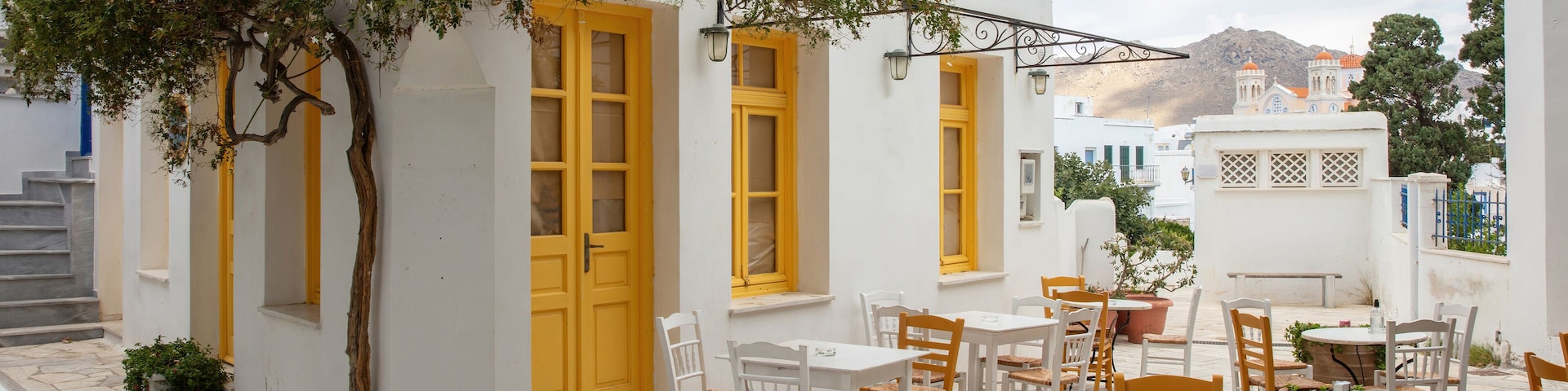 Greece. Tinos island Cyclades. Outdoors traditional cafe with yellow windows at Pyrgos village