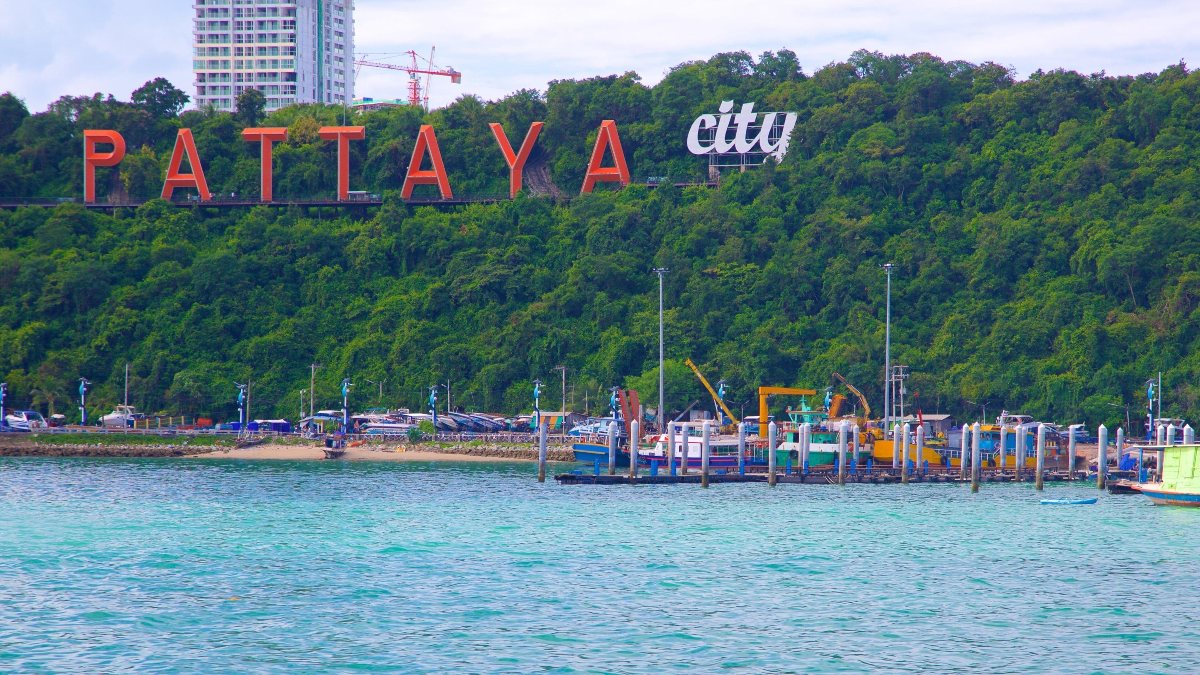A waterfront with boats, a pier, and a sign reading "PATIYA city".