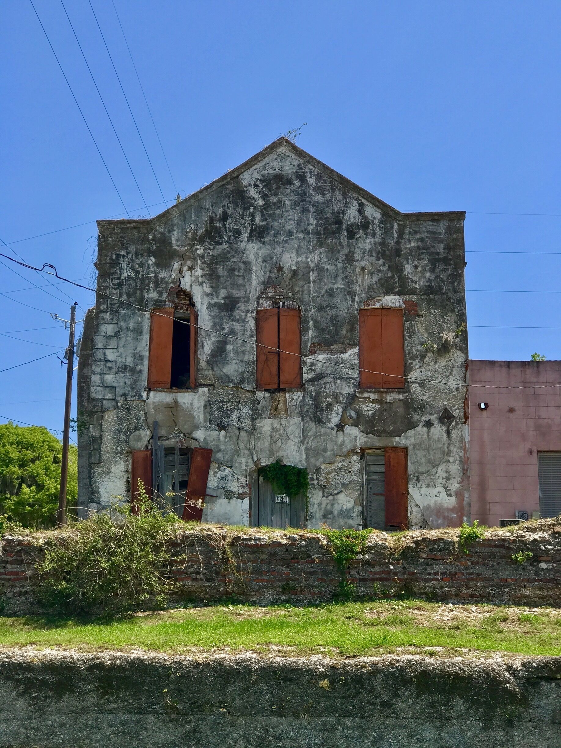 Built in 1813 the two-story cotton warehouse and ship chandlery survived the burning of Darien in June 1863 by raiding Union forces from St. Simons Island.  It was the mercantile establishment of Adam Strain from ca. 1870 to 1897.  A portion of the structure was used to house the Darien Bank from 1913 to 1961. The Adam Strain Building is a stuccoed tabby two-store warehouse and the oldest commercial building in Darien. The tabby ruins directly behind the Adam Strain Building, sitting on the waterfront, are reminders of the time when Darien was one of the leading Atlantic commercial ports for the export of cotton and timber.  There were two separate eras of Darien's commercial success; the first, featuring the export of cotton grown inland and rafted down the river, lasted from c. 1810 to 1845.  The second saw Darien's rise from total destruction in the Civil War to become the second-leading timber exporting port on the southern coast from c. 1870 - 1910.  These ruins were constructed c. 1815-1830.  The Darien waterfront was rebuilt after devastating fires in 1812 and 1824.  The Adam Strain building is currently abandoned and in unsafe conditions.  The current owners have attempted to demolish the building, but local preservationists are working to save it.  