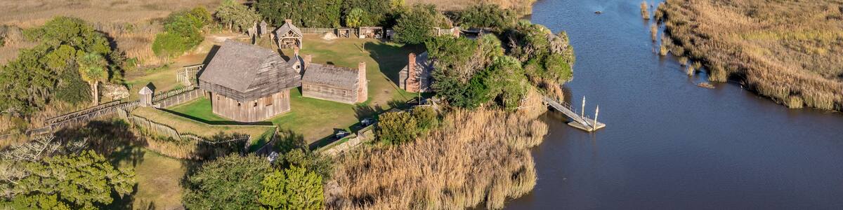 Aerial view of Fort King George historic site, oldest English fort on the Georgia coast from the 17th century with wooden palisade, gun ports for cannons blue cloudy sky near Darien Georgia USA