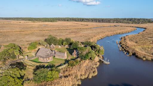 Aerial view of Fort King George historic site, oldest English fort on the Georgia coast from the 17th century with wooden palisade, gun ports for cannons blue cloudy sky near Darien Georgia USA