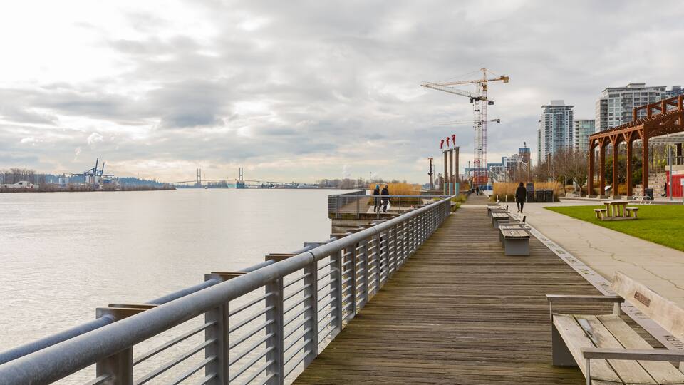Pier and walkway by riverside. Beautiful river park in New Westminster in overcast day.